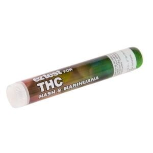 En hvid plastikkasse med en gennemsigtig låg, der viser flere farvede reagensstrimler indeni. Strimlerne har farver i nuancer af grøn, orange og rød, og hver strimmel er markeret med tal og en indikatorlinje. Kassen har en tydelig etikette med tekst, der angiver testens formål. Det hele er placeret på en lys overflade.