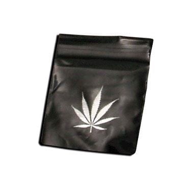 En stor taske præsenterer sig i en sølvfarvet tone med et bladmotiv i relief. Overfladen har en glat, skinnende tekstur, der reflekterer lys og skaber dybde i mønstret. Tasken har en rummelig form med robuste håndtag, der er fastgjort med metalbeslag. Indvendigt er der en ensfarvet, mørkere foring, der kontrasterer med den ydre glans.