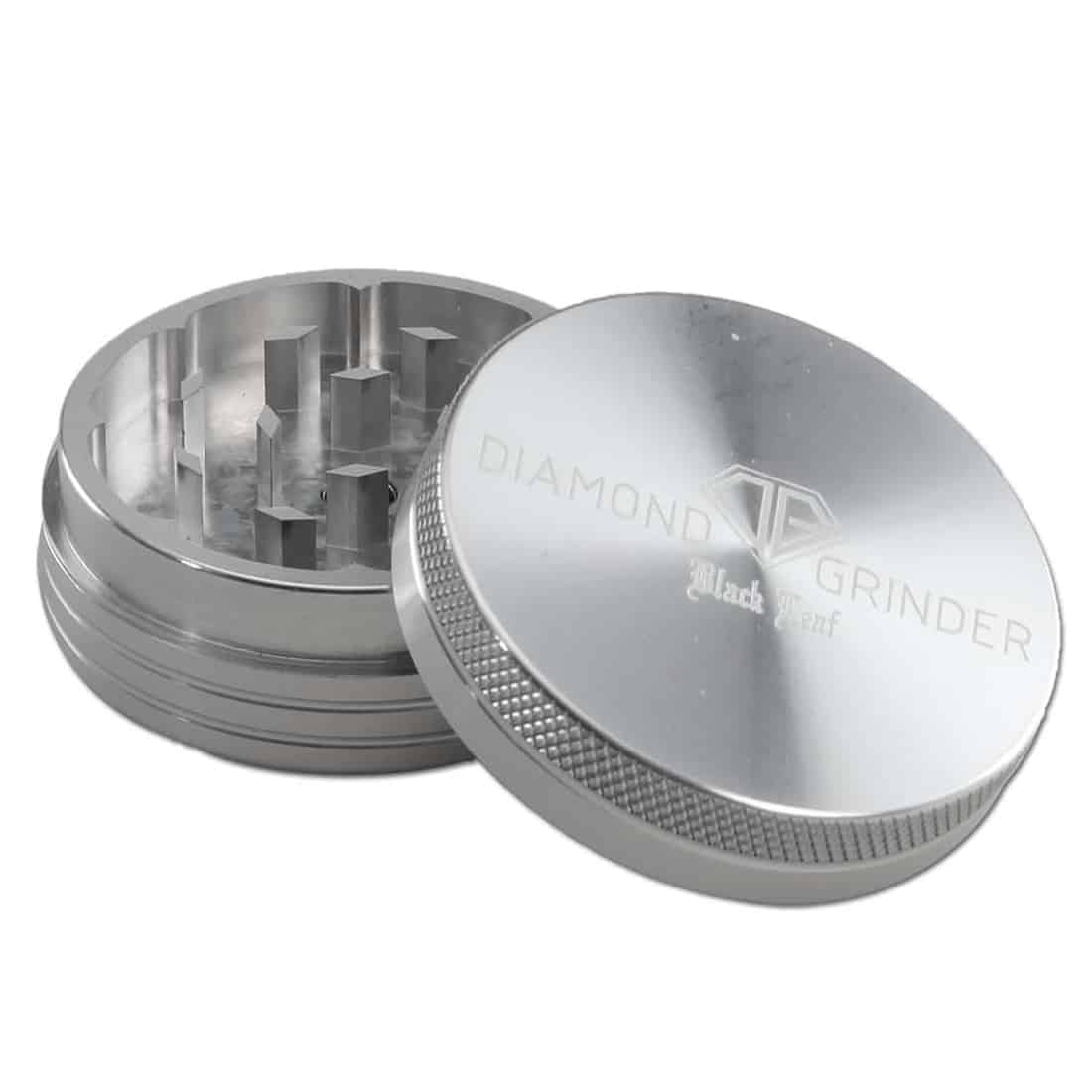 Sorte, diamantformede blade i metal pryder et sølvfarvet, to-delt vedhæng. Det glatte, skinnende sølv reflekterer lys, mens de matte blade giver en kontrast. Vedhængets overflade har en fin struktur, som tilføjer dybde. Kanten på bladene er skarp og veldefineret, hvilket fremhæver den geometriske form og elegance i designet.