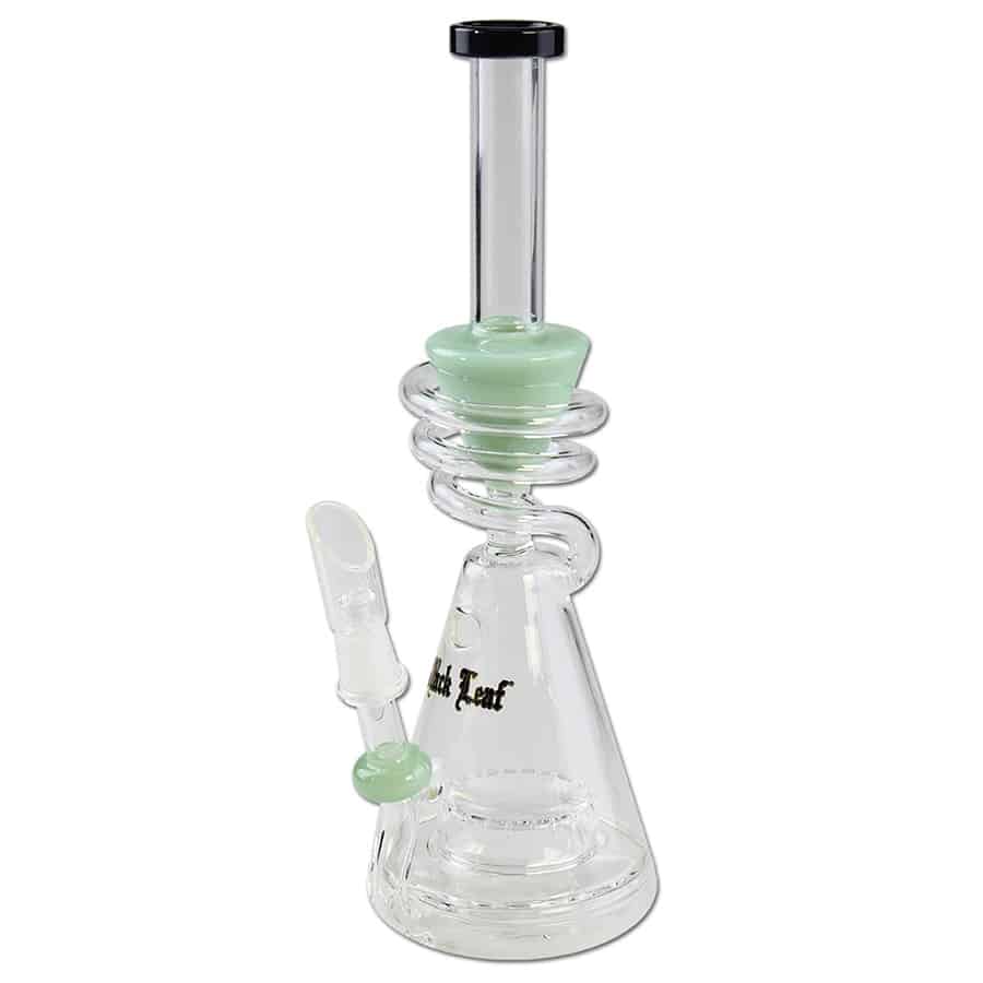 En sort bong med en spiralformet stængel i jadegrøn farve. Bongen har en glat, blank overflade og en afrundet skål i toppen. Spiralens form skaber en dynamisk effekt, mens det sorte glas fremhæver den grønne nuance. Bunden er stabil og bred, hvilket sikrer en solid placering. Kanten er let krummet for komfort.