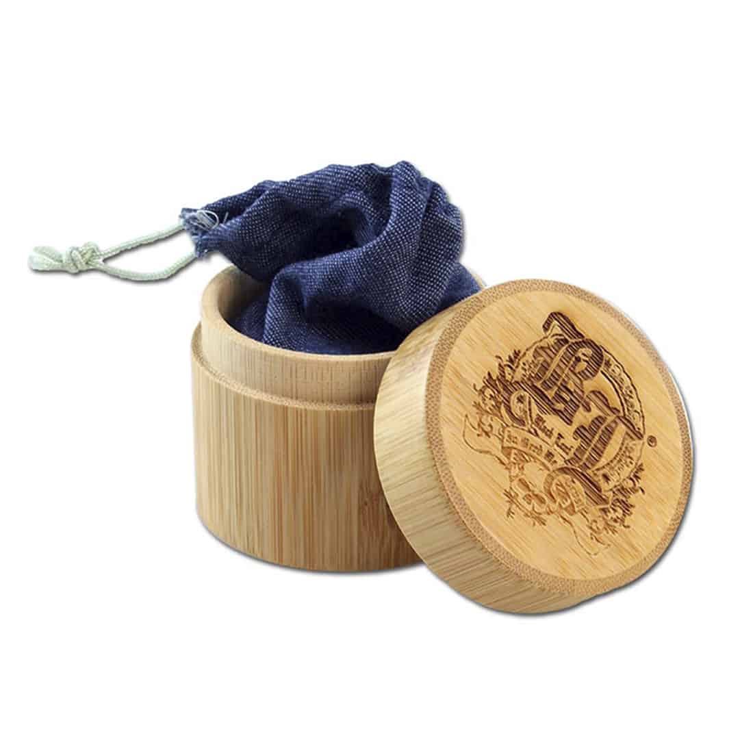 En sort, bladformet kværn i rustfrit stål præsenterer sig med en glat, mat overflade. Den har en rund krop, der afsluttes med en spids ende, og en tydelig, skridsikker tekstur langs kanten. Kværnen har et enkelt drejehjul med en praktisk, ergonomisk form, der giver et godt greb. Det minimalistiske design udstråler elegance.