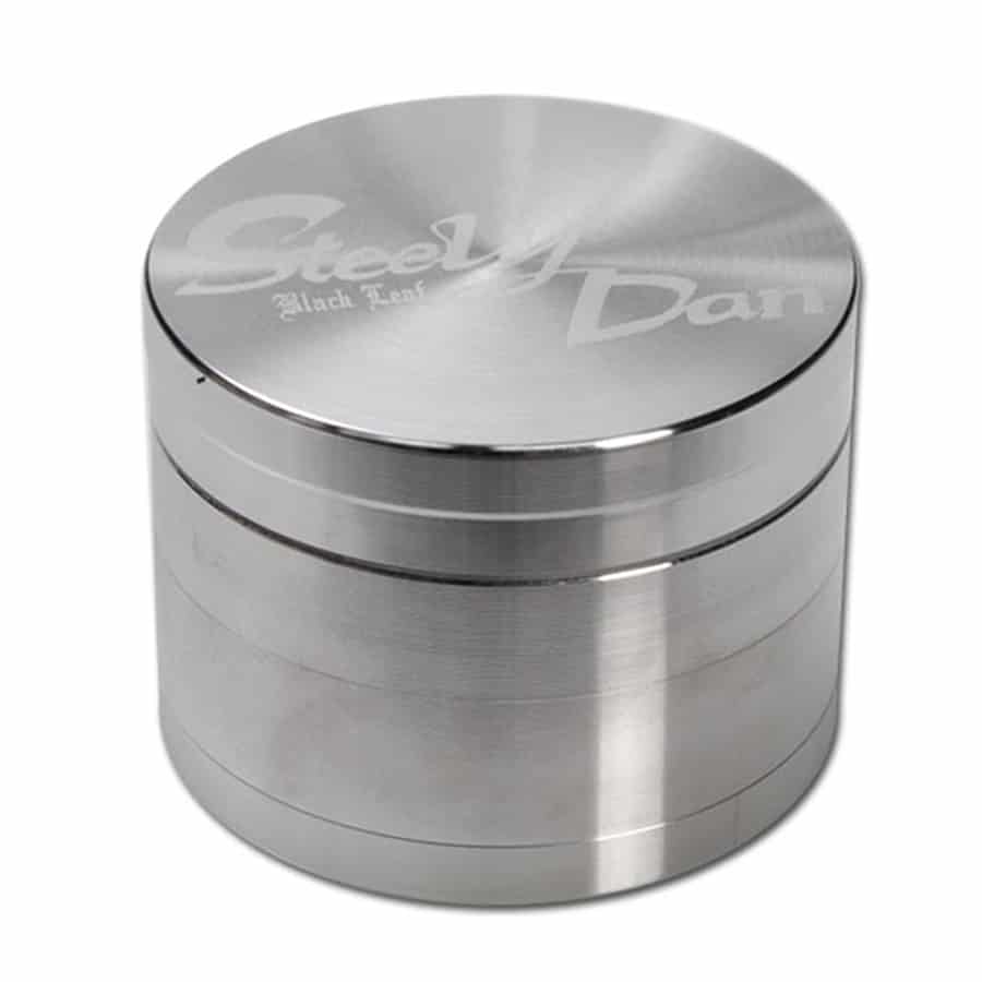 En mørk, elegant plade med en glat overflade præsenterer et stiliseret bladdesign, hvor de fine detaljer fremhæves med en metallisk glans. Bladets konturer er bløde og organiske, mens den sorte farve danner en stærk kontrast til det lysere, reflekterende element. Mønsteret er delikat og har en let struktureret tekstur, der tilføjer dybde.