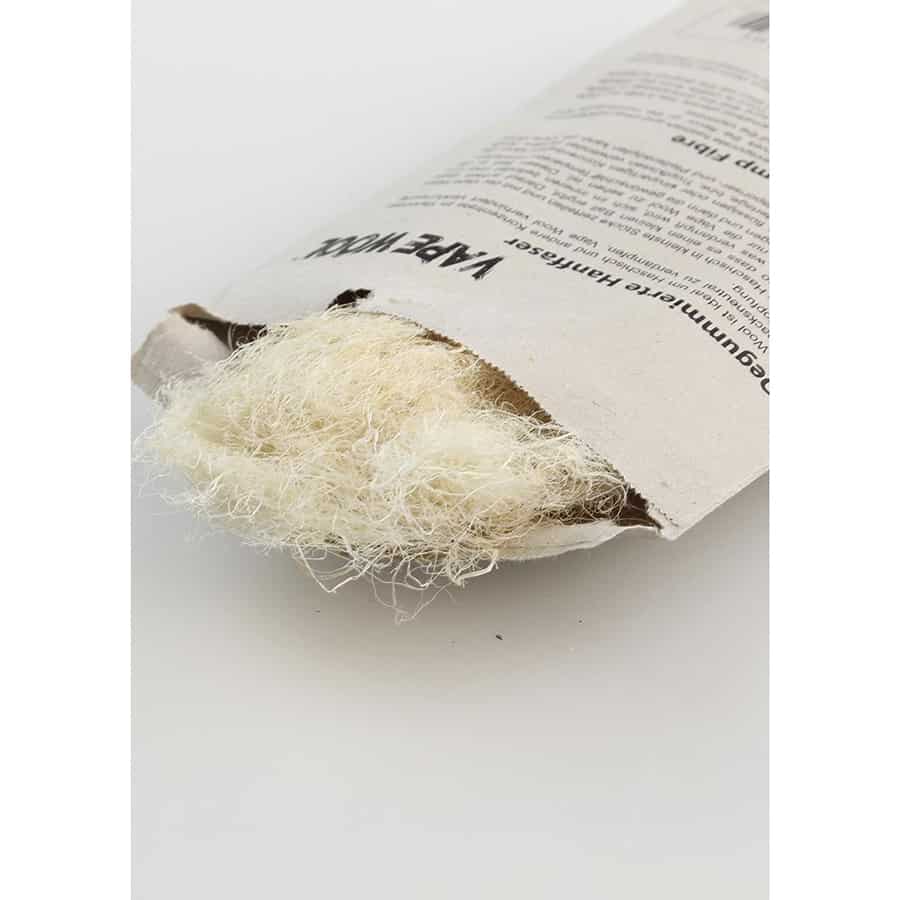 Et sort blad i en organisk form er fremtrædende, med en fin, strukturert overflade, der afspejler lyset. Materialet ser ud til at være en kombination af uld og hamp, hvilket giver en let tekstur. Farven er dyb sort, der skaber kontrast til eventuelle lysere elementer. Kanten er blød og naturligt afrundet.