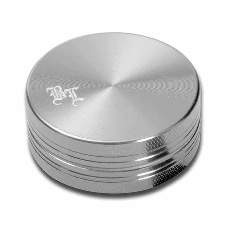 En sort, rund grænseslicer med en diameter på 40 mm præsenterer et elegant design. Overfladen er glat, mens bladene indeni har en skarp, ridset tekstur til effektiv kværnning. Den øverste del har en lille knap i midten, der giver et strømlinet udseende. Farven er ensartet, og materialet ser ud til at være metal med en mat finish.