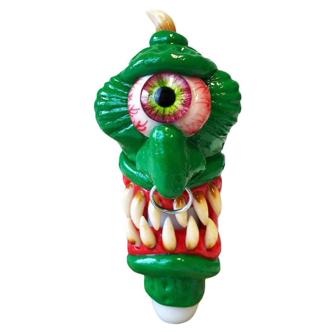 En glasrørformet genstand præsenterer sig med en transparent, grønlig farve og en glat, skinnende overflade. Den har en krum form med en bredere bund og en slankere top. Mønstre af små, farverige prikker pryder overfladen, hvilket giver en livlig effekt. Røret afsluttes med en sort, rund del, der fungerer som mundstykke.