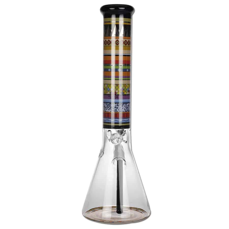 En 37 cm høj totemflaske i klart glas med en cylindrisk form. Flasken har en glat overflade, der reflekterer lys, hvilket skaber en glitrende effekt. Den er forsynet med en bred, flad bund for stabilitet og har en smal hals, der afsluttes med en let svunget åbning. Flaskens design er enkelt og elegant, uden ekstra dekorationer.