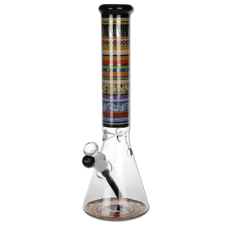 En totémformet glasflaske med en højde på 37 cm præsenterer sig med en klar, glansfuld overflade. Den har en cylindrisk form og er dekoreret med en let bølget tekstur. Toppen er afsluttet med en smal, rund åbning, og flaskens bund er flad, hvilket giver stabilitet. Farven er en lys, næsten gennemsigtig tone, der fanger lyset.