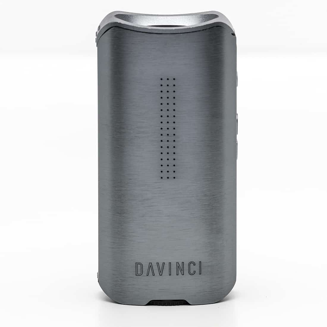 Da Vinci IQ2 er en kompakt enhed med en mat, grafitgrå overflade. Den har en afrundet form med bløde kanter og en lille skærm, der er indlejret i toppen. Knapperne er diskrete og placeret på fronten, mens en tynd, elegant ledning tilsluttes enheden. Texturen er glat, med en let refleksion i lyset.