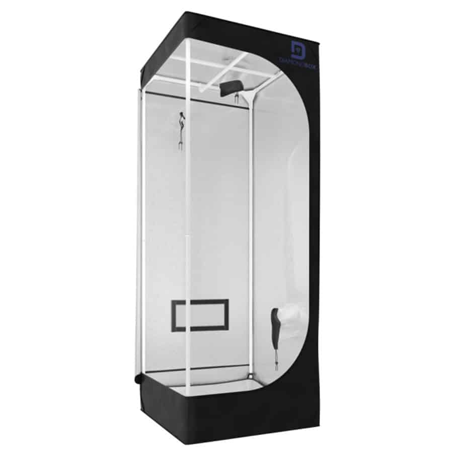 En firkantet beholder med en sølvfarvet overflade pryder midten, hvor lyset reflekteres og skaber glimt. Den har en glat, metallisk tekstur og en let buet top, der afslutter med en skarp kant. På fronten er der en diskret låsemekanisme, mens siderne er enkle uden yderligere dekorationer, hvilket giver et minimalistisk udtryk.