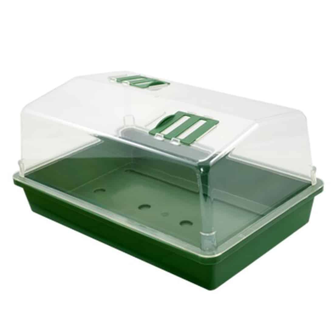 Et lille drivhus i grøn plast, måler 38 x 24 x 19 cm. Drivhuset har en rektangulær form med en gennemsigtig plastlåg, der har en buet top. Facaden har to åbninger til ventilation, og siderne er glatte med en ensartet grøn farve. Bunden er flad og stabil, hvilket giver et solidt fundament.