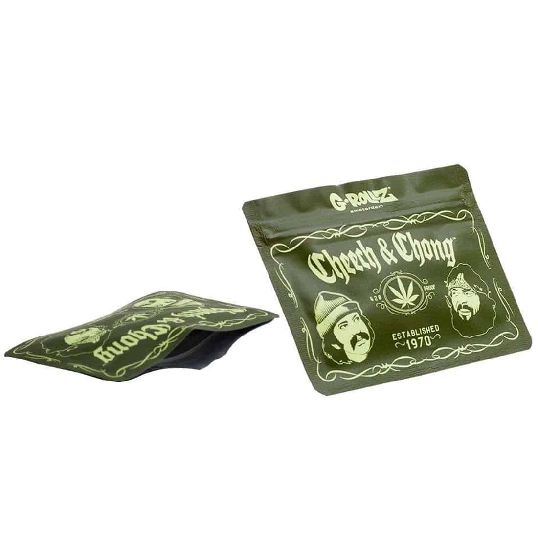 En plade med et farverigt design prydet af illustrationer af to karakterer. Baggrunden er domineret af nuancer af grøn og lilla, med grafiske elementer i sort og hvid. Teksten "Greatest Hits" fremstår tydeligt i en stor skrifttype, mens mindre tekst og symboler er placeret strategisk omkring karaktererne. Materialet ser glat og skinnende ud.