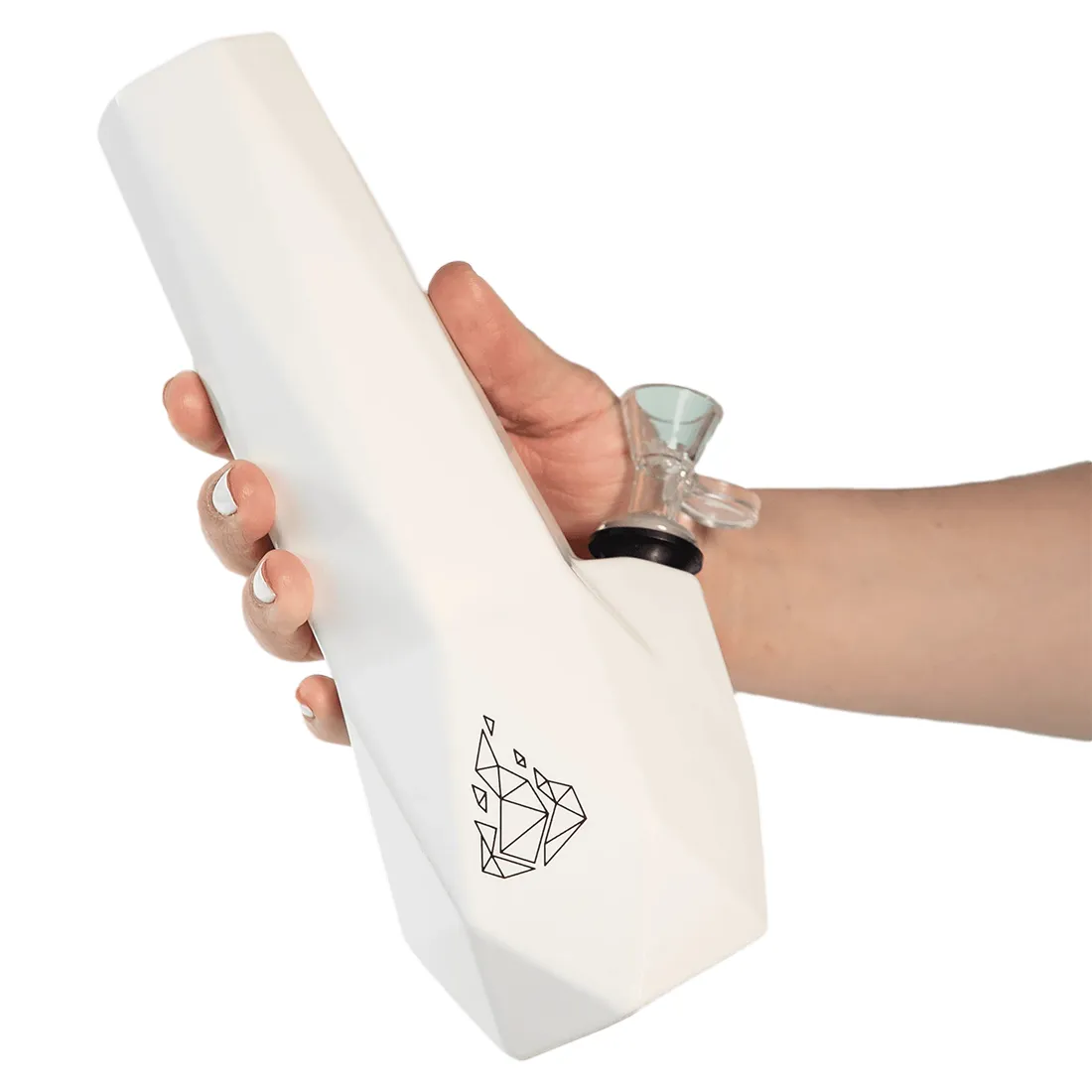 En hvid, hexagonal keramisk vandbong pryder overfladen med glatte, ensartede flader og skarpe vinkler. Den har en rund bund, der giver stabilitet, mens et rør strækker sig opad fra siden, afsluttet med en bred åbning. Den matte overflade er fri for mønstre, hvilket fremhæver den minimalistiske design. Højden er cirka 25 cm.