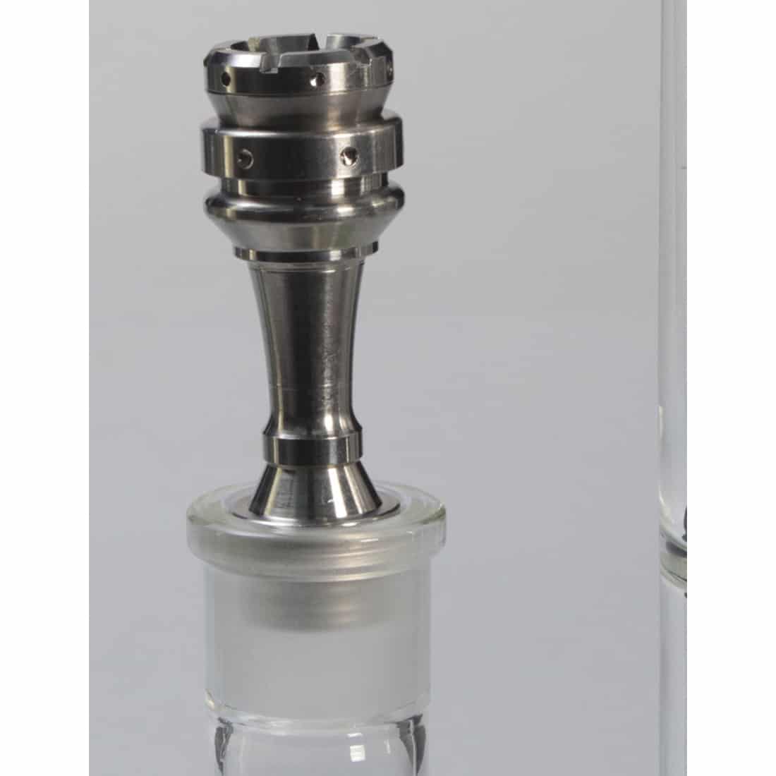 En universal olie-nail i titanium præsenteres med en glat, metallisk overflade, der skinner i lyset. Den har en konisk form, der afsluttes med en flad spids. Overfladen er dekoreret med fine, præcise skær, der skaber et struktureret udseende. Farven er en dyb, sølvgrå, hvilket fremhæver materialets holdbarhed og styrke.