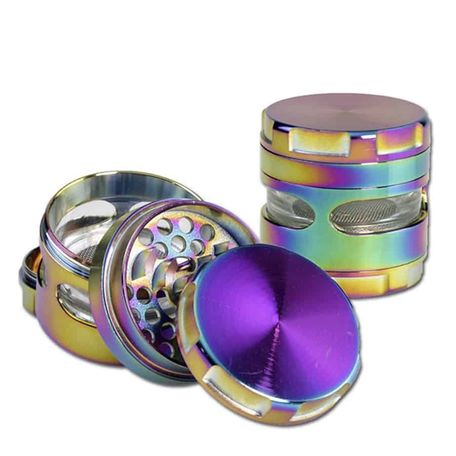 En metalgrinder med en oliefarvet overflade præsenterer sig i en rund form med en diameter på 63 mm. Overfladen har en glat og skinnende finish, der reflekterer lys. Grinderens øverste del har en let skruefunktion og et mønster af skarpe tænder indeni, mens den nederste del er udstyret med en lille åbning til opbevaring.