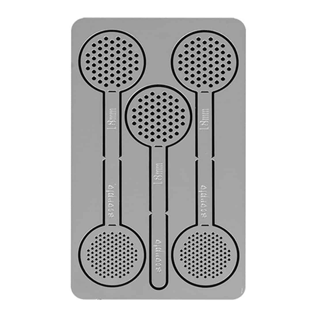 En sølvfarvet ske med en glat, poleret overflade og en let buet form pryder midten af billedet. Skeens skaft er slankt og elegant, mens selve skefladen har en oval form. Omkring skeen er der en hvid, struktureret overflade, der giver kontrast til skeens glans. Risten er indsat med præcise, jævnt fordelte åbninger.