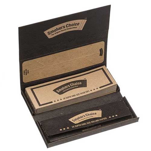 En papæske med en naturlig, brun tone præsenterer sig med en mat overflade. På forsiden er der en tydelig, sort tekst, der angiver produktets navn. Æsken har en åbningsflap, der er let bøjet opad. Indeni ses flere papirruller, der har en glat, hvid overflade med en let skinnende finish.