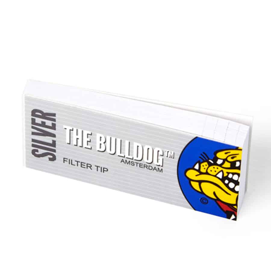 Filtrene er cylindrisk formede med en glat, sølvfarvet overflade, der reflekterer lys. Hver enhed har et klart og præcist snit i enden, hvilket skaber en skarp kant. På den øverste del er der en tekst med sort skrift, der angiver produktets navn og specifikationer. Baggrunden er neutral, hvilket fremhæver filtrenes design og farve.