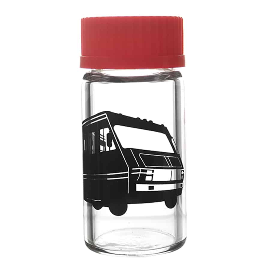 En gennemsigtig glasbeholder med en skruelåg i metal pryder midten af kompositionen. Beholderen har en rund form og er fyldt med tørrede urter, der har varierede grønne nuancer. Foran beholderen ligger en lille, hvid skål med et dekorativt mønster. Baggrunden er en naturlig træoverflade, der tilføjer varme til scenen.