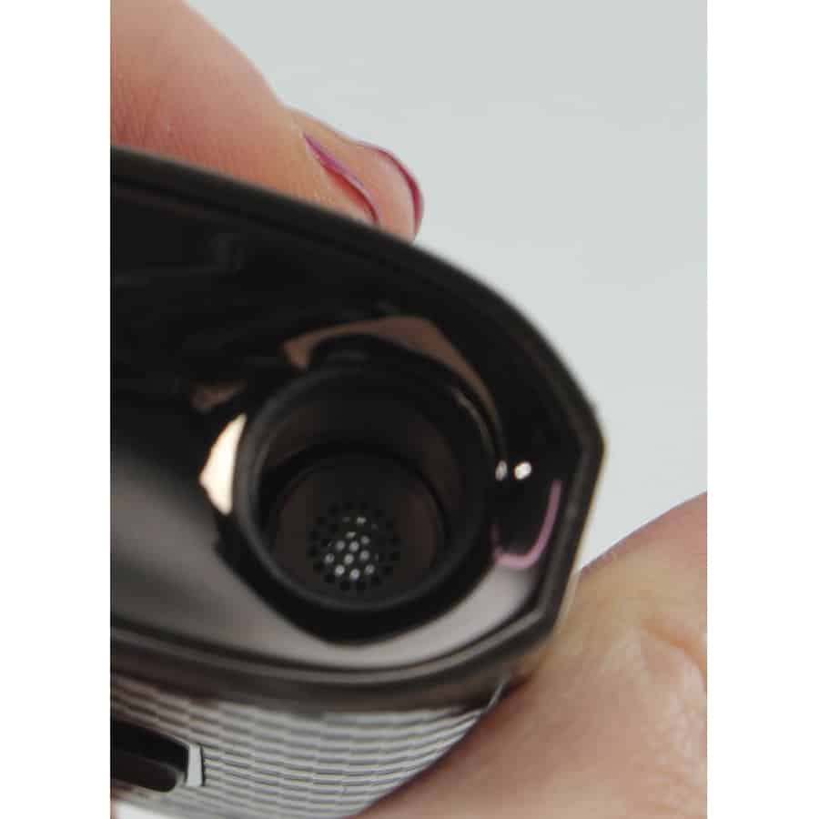 En brunt farvet vaporizer med en glat, mat overflade. Den har en oval form med afrundede kanter og en tydelig knap på forsiden. Øverst er der et gennemsigtigt panel, der viser en digital skærm med grønne tal. En metalring omkranser toppen, og der er små lufthuller på siden, der giver en struktureret tekstur.