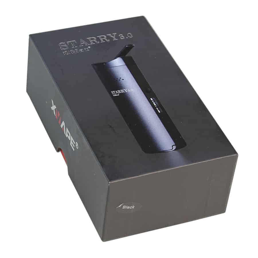 En kompakt vaporizer præsenterer sig i en mat sort finish med en glat overflade. Den har en oval form med afrundede kanter og en tydelig LED-skærm på fronten, der viser temperaturindstillinger. Knapperne er placeret under skærmen, mens en lille åbning til dampudslip findes på toppen. En elegant, minimalistisk designstil præger hele enheden.