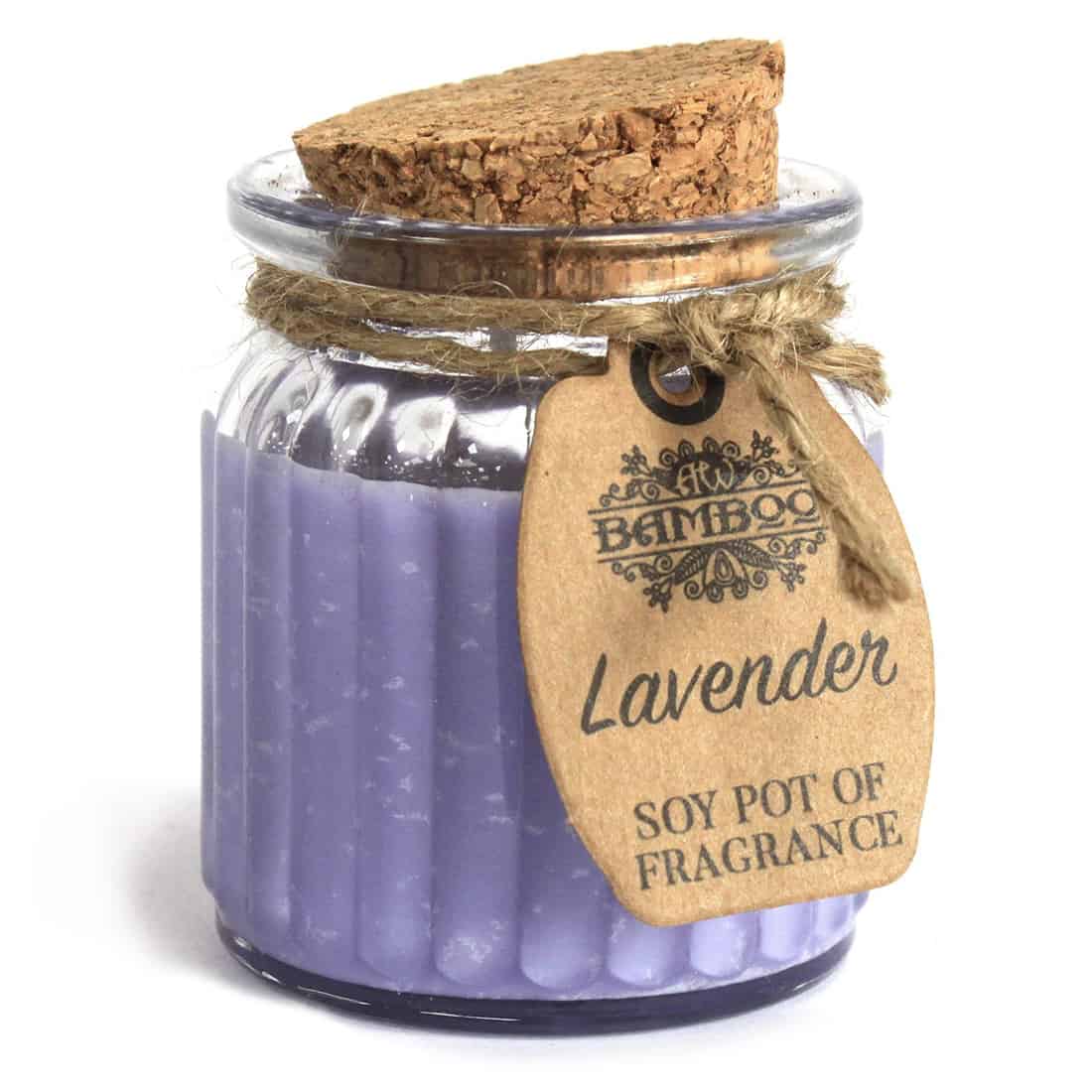 En rund, lysestage i bambus med en glat, naturlig overflade pryder en hvid flade. Stagen er let buet i formen, hvilket giver en organisk æstetik. Indeni er der en lavendelduftende sojavokslysekrone, der er lys lilla. Den bløde farve kontrasterer med det beige bambus, og der er en enkel, elegant silhuet uden yderligere dekorationer.