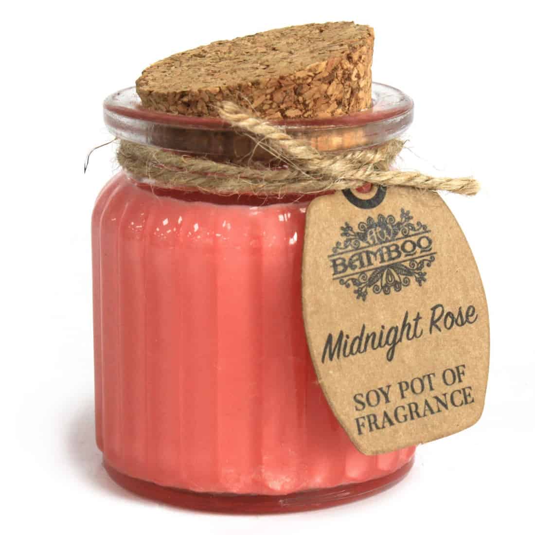 Et cylindrisk lys med en glat, lys rosa overflade står i centrum. Materialet fremstår som en kombination af bambus og sojavax, hvilket giver en naturlig og miljøvenlig æstetik. Øverst er der en fin, hvid væge, der stikker op fra lysets midte. Det enkle design er elegant og minimalistisk, med en let glans, der reflekterer lys.