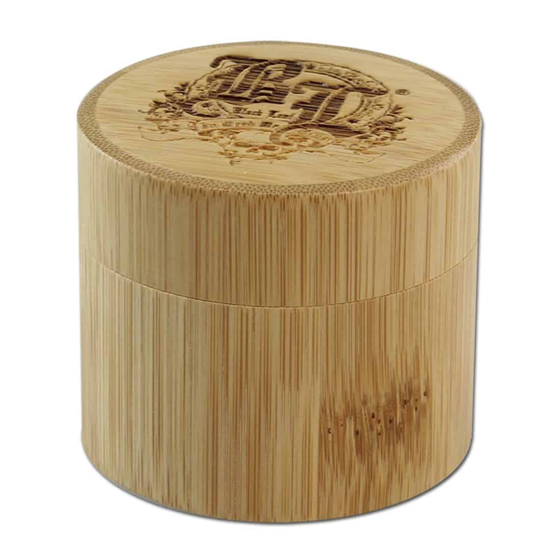 En sort bladformet krydderikværn i rustfrit stål præsenterer sig med en glat, metallisk overflade, der reflekterer lys. Kværnen har en elegant, strømlinet form med et tydeligt håndtag. Øverst ses et skruelåg med en fin tekstur, mens bunden har små udskæringer, der muliggør krydderiets passage. Det hele fremstår stilfuldt og funktionelt.