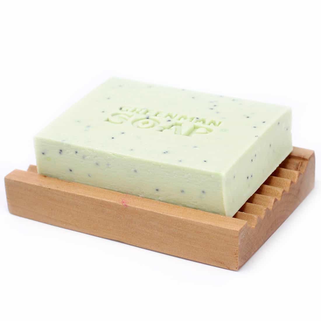 En grøn, rund sæbe med en glat overflade og en let skinnende finish. Sæben vejer 100 gram og har en præget tekstur, der danner et mønster af små prikker. På forsiden er der en tydelig inskription med teksten "Antiseptic Spot Attack", der er skrevet med hvid skrift på en mørkere grøn baggrund.