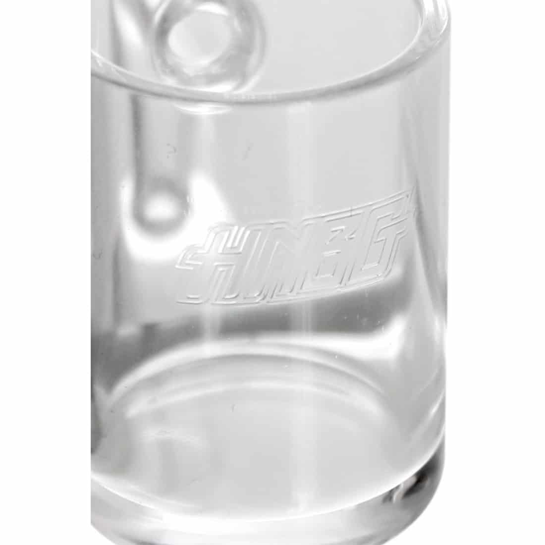 En klar, gennemsigtig banger med en flad bund og en udvidet hals pryder midten. Materialet er borosilikatglas, der reflekterer lyset og skaber en glansfuld overflade. På bangerens inderside er der fine, buede linjer, der giver en organiske form. Farven er næsten farveløs, hvilket fremhæver dens elegante design.