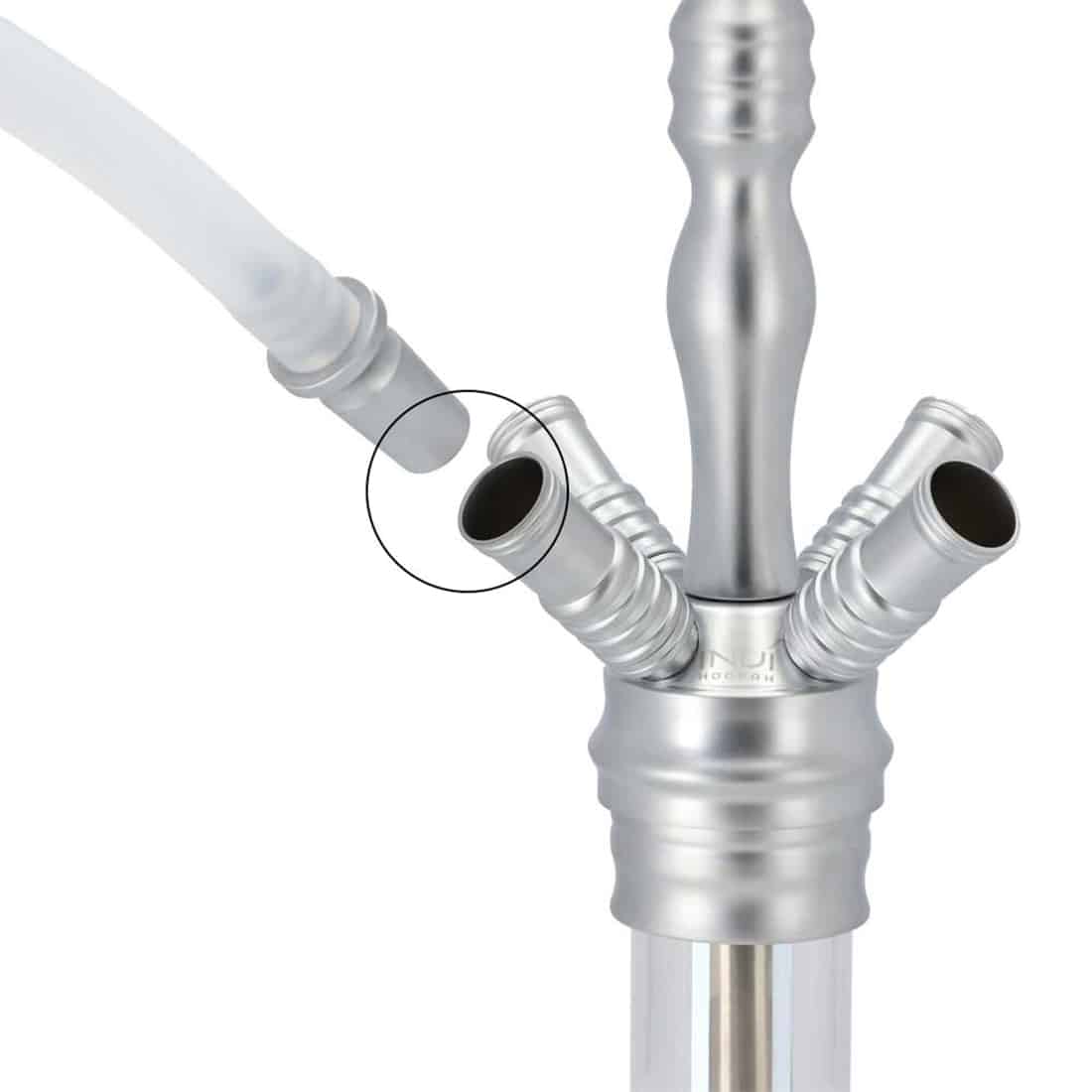 En klar, skinnende glasflaske med en elegant, slank form. Flaskens overflade reflekterer lys og skaber glimtende effekter. Den har en rund bund og en smal hals, som afsluttes med en skruehætte. Flasken er gennemsigtig, hvilket gør indholdet synligt, og den har en subtil glans, der fremhæver dens glatte tekstur.