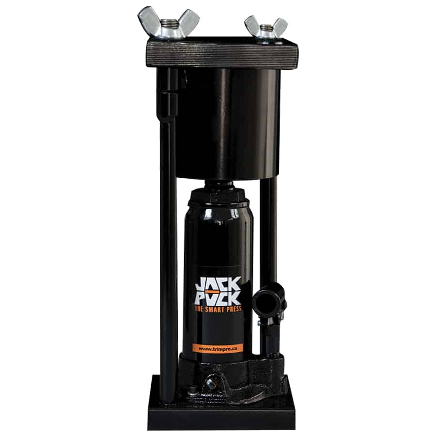 En rund, robust hydraulisk presse med en stærk, metalstruktur i en mørk farve. Pressens plade er glat og cirkulær, omgivet af en solid ramme med tydelige svejsninger. Håndtaget er placeret på siden, med en gummibelægning for bedre greb. Der ses en trykmåler, der indikerer kraften, samt et sikkerhedssymbol på pressens krop.