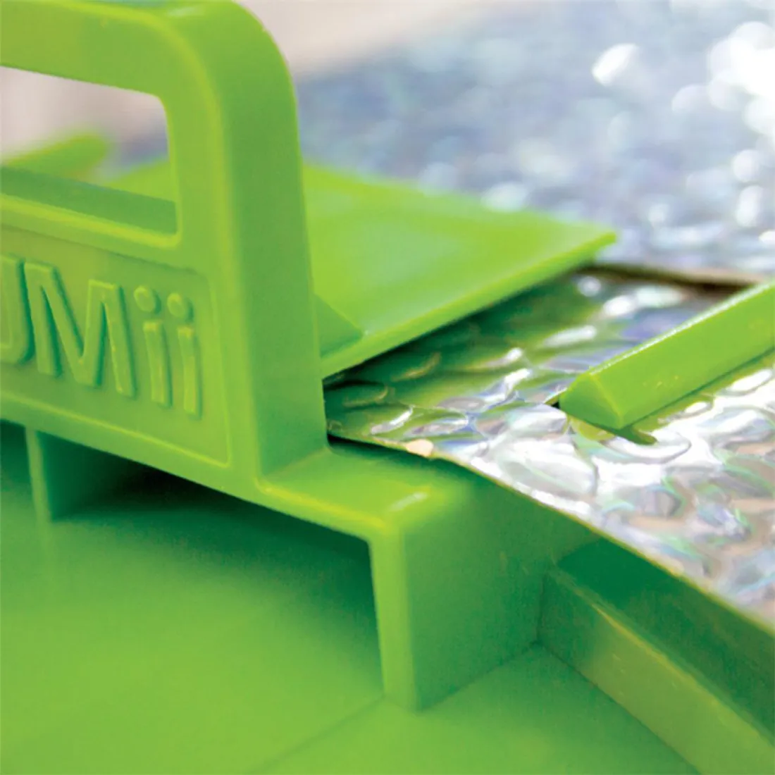 En cylindrisk reflektor med en diameter på 125 mm præsenterer sig i et metallisk sølvfarvet materiale. Overfladen er glat og skinnende, hvilket skaber refleksioner af lys. Den er udstyret med en flad bund, der muliggør stabil placering. Kanten er let buet, hvilket giver en strømlinet form, og der er synlige ventilationshuller langs siden.