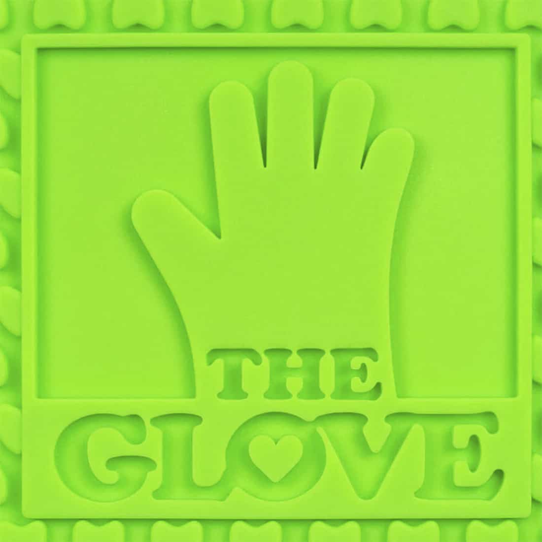 En håndbeskytter i en levende lilla farve pryder overfladen. Materialet fremstår som silikone, hvilket giver en blød og fleksibel tekstur. Der er tydelige fingeraftryk med adskilte sektioner til hver finger, hvilket sikrer en god pasform. Overfladen har en glat finish, der reflekterer lys let, og der er indgraverede symboler og tekst på håndbeskytteren, der tilføjer detalje.