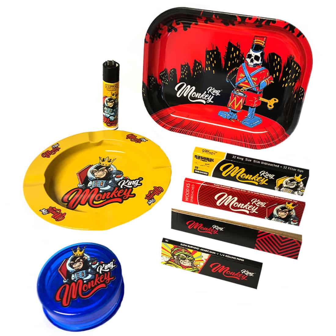 En sætning med en hvid og rød farvekombination prydet med illustrerede ansigtstræk af en abe. Æsken har en rektangulær form med en glat, blank overflade. Øverste del viser en farverig, detaljeret grafik, der omfatter symboler og tekst. Indholdet inkluderer værktøjer og materialer til kreativ leg, arrangeret i sektioner inden i æsken.