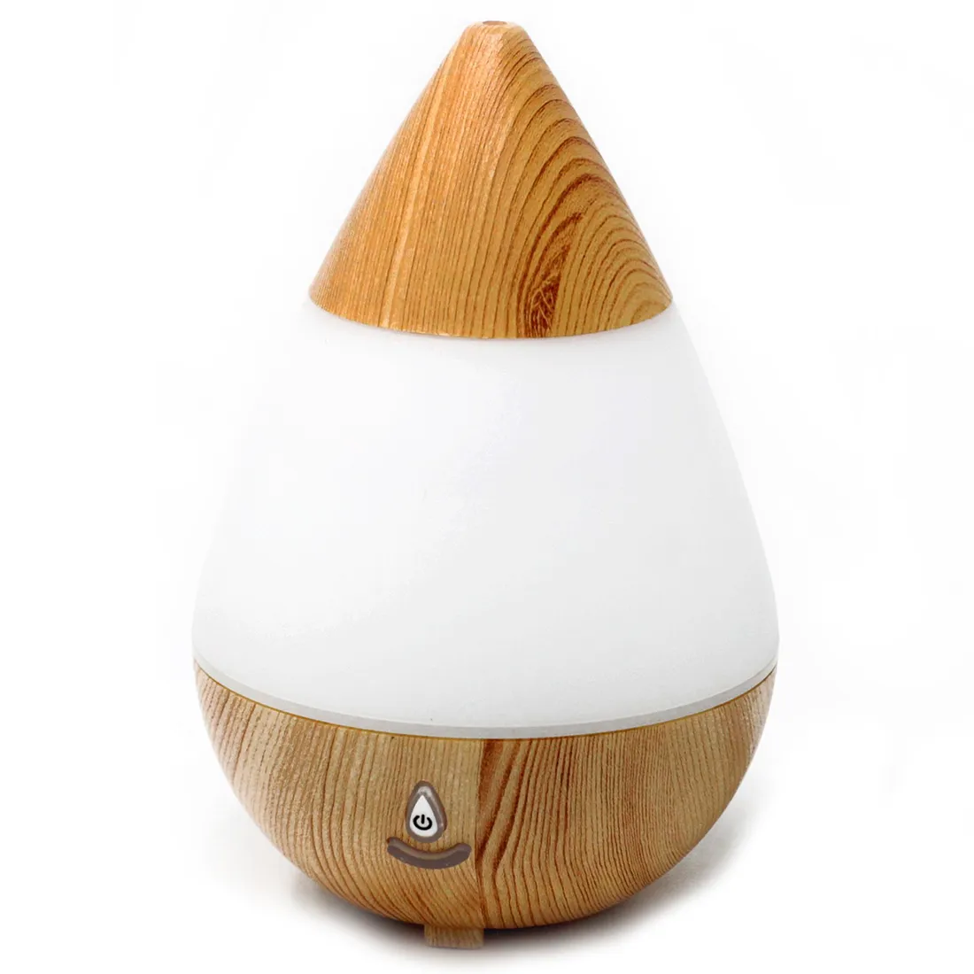 En dråbeformet aromadiffuser i lys træfarve pryder overfladen. Den har en glat, naturlig tekstur med synlige åretegninger. Fronten har en rund knap med et subtilt lys, der indikerer funktion. Den nederste del er flad, hvilket giver stabilitet. En USB-port er placeret på bagsiden, hvilket gør den praktisk til brug.