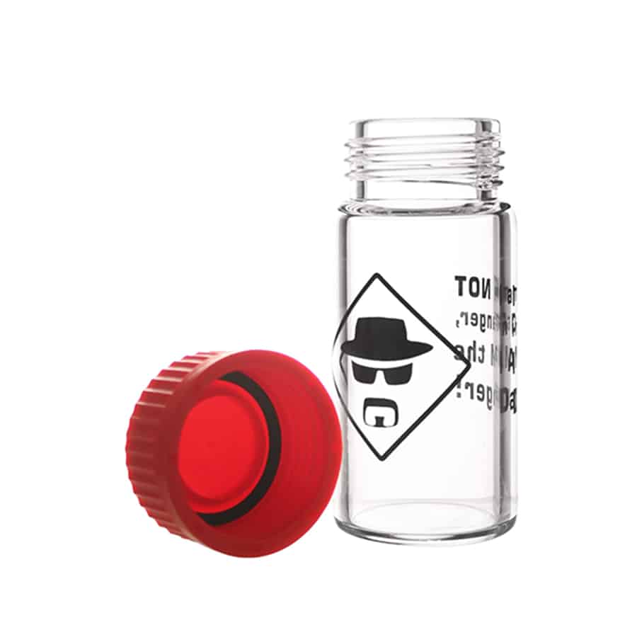 Rundt glaskrukke med en tætsiddende, sort plastlåg. Krukken har en klar overflade, der afslører indholdet af tørrede urter. Låget prydes af teksten "I am the danger" i hvid, fed skrift. Krukkens overflade reflekterer lys, hvilket fremhæver dens glatte tekstur. Bunden er flad, hvilket sikrer stabilitet ved placering.