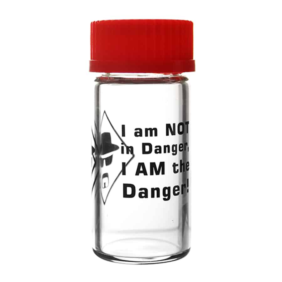 En klar glasbeholder med en tætsluttende sort metal låg pryder overfladen. Beholderens cylindriske form har en glat overflade, der fremhæver indholdet. Låget har en simpel, men effektiv udskæring til nem åbning. Et hvidt, grafisk design med tekst står i kontrast til glasets gennemsigtighed, hvilket skaber et moderne og stilrent udtryk.