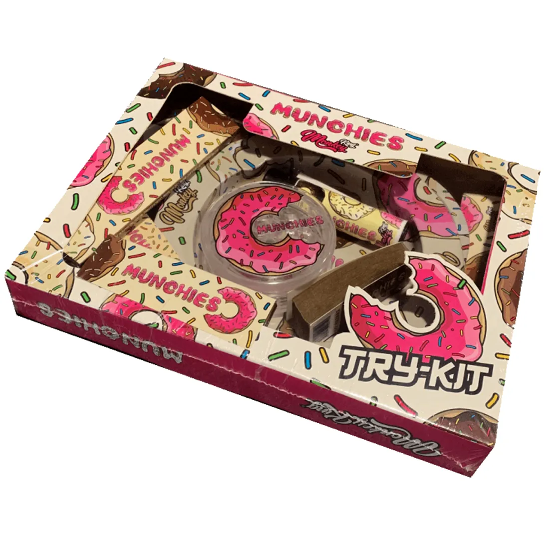 En samling af forskellige elementer præsenteret i en farverig æske. Æsken har et grafisk design med illustrationer af en abe og farverige mønstre. Indholdet inkluderer flere små beholdere med forskellige nuancer, der spænder fra lyse til mørke farver. Hver beholder er forsynet med en skruehætte. Baggrunden er neutral for at fremhæve æskens detaljer.