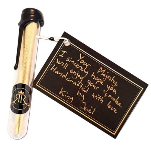 En cone i en dyb gylden farve pryder midten af kompositionen, fremstillet af et håndværksmæssigt materiale, der fremstår glat og skinnende. Den er udsmykket med detaljerede, indviklede mønstre, der tilføjer tekstur og dybde. Omkring conen ses en subtil refleksion, som fremhæver dens luksuriøse udseende og håndværkets finesse.