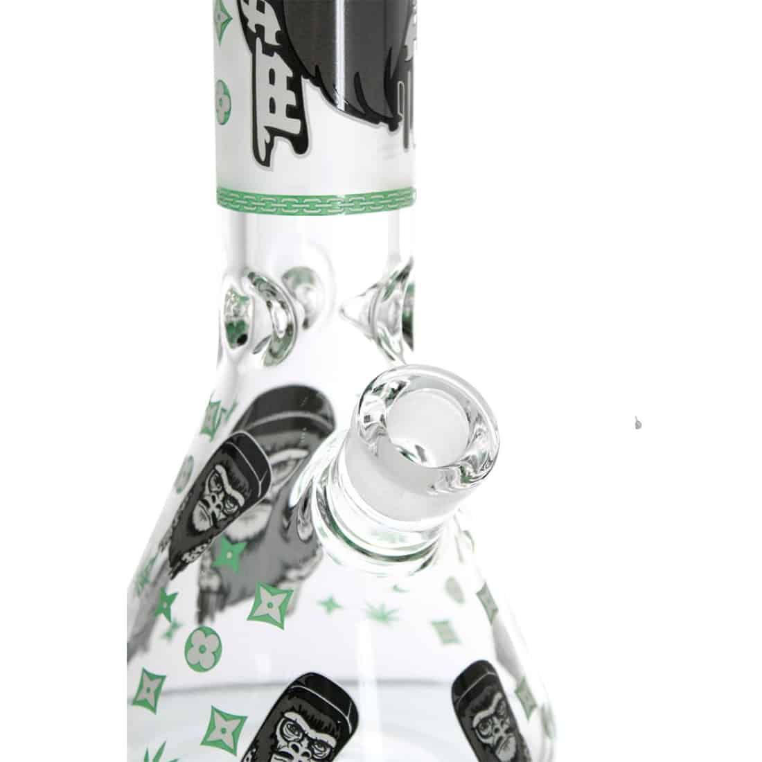 Mørkegrønne og sorte nuancer pryder en abstrakt apeformet figur, der har en glødende effekt. Overfladen er glat med en let skinnende tekstur, der fremhæver detaljerne i ansigtet og lemmerne. Øjnene er fremtrædende og lysende, mens kroppen har en organisk form, der skaber en dynamisk komposition. Figuren står på en flad base, der stabiliserer den.