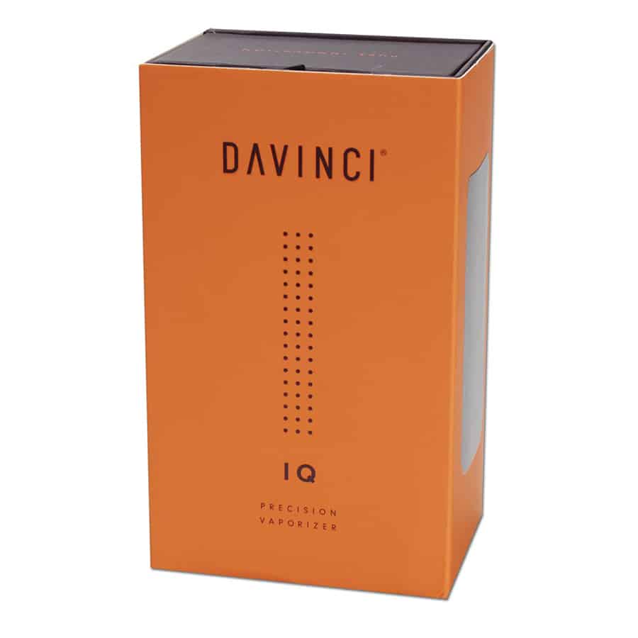 En rektangulær boks i sort med en glat, mat overflade prydet med en hvid logo-tryk på forsiden. Låget er let skrånet, hvilket giver et moderne udtryk. Indvendigt er boksen indrettet med en blød, grå skumindsats, der holder enhederne sikkert på plads. Kanten er let afrundet, hvilket skaber en behagelig grebsflade.