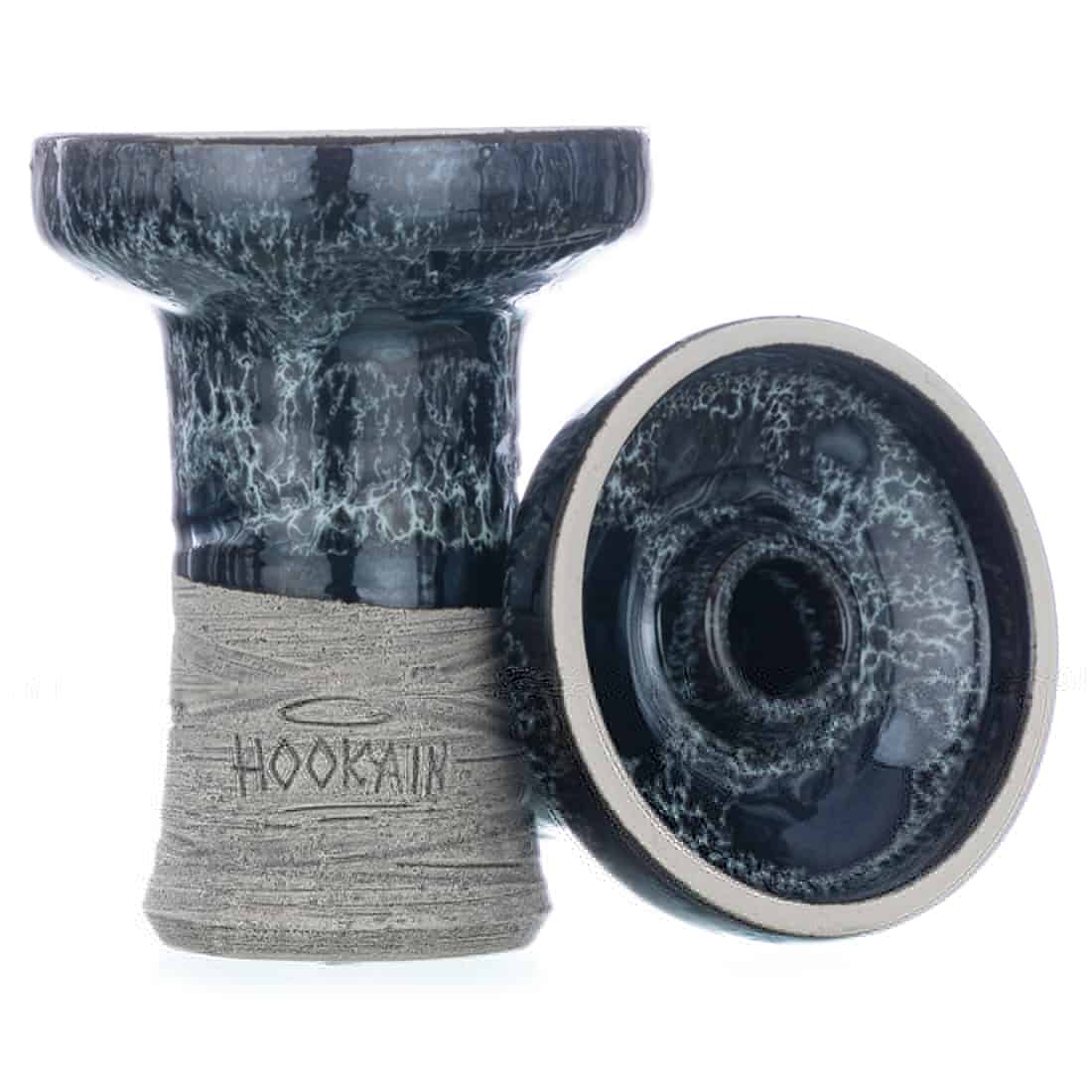 En keramisk skål prydet med et glat, glaseret overflade i nuancer af blå og hvid. Skålen har en rund form med en bred kant og en dyb bund. Indersiden er dekoreret med en subtil, bølget struktur, mens ydersiden har en ensartet, glansfuld finish. Skålen står på en flad base, der giver stabilitet.