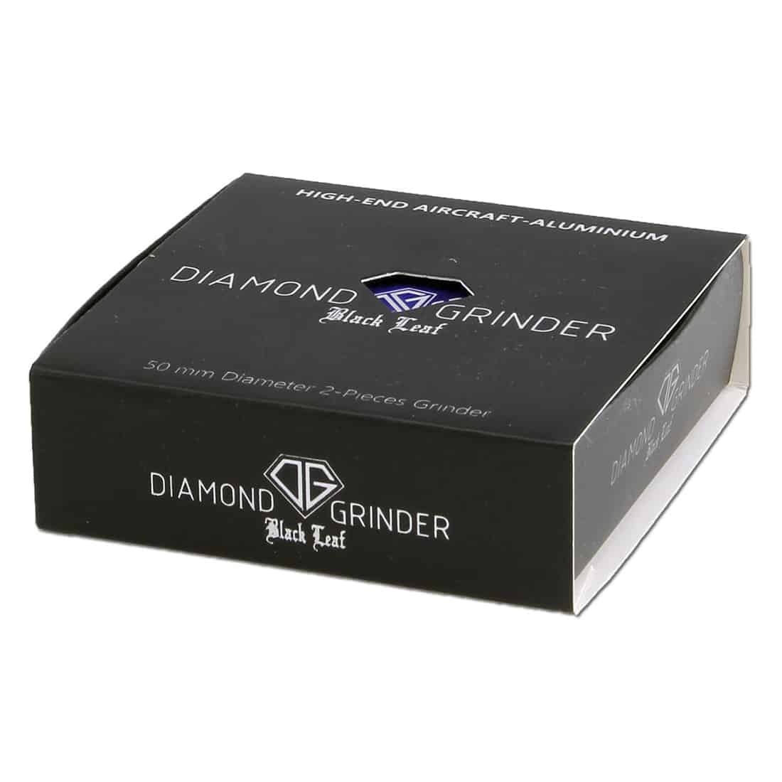 En sort, diamondformet kasse med en glat overflade og en mat finish pryder midten. Kassen har en synlig lukning, der er placeret centralt, og dens hjørner er let afrundede. Øverst er der indgraveret et mønster, der minder om blade, hvilket skaber en struktureret tekstur. Kassen måler 50 mm og fremstår elegant og moderne.