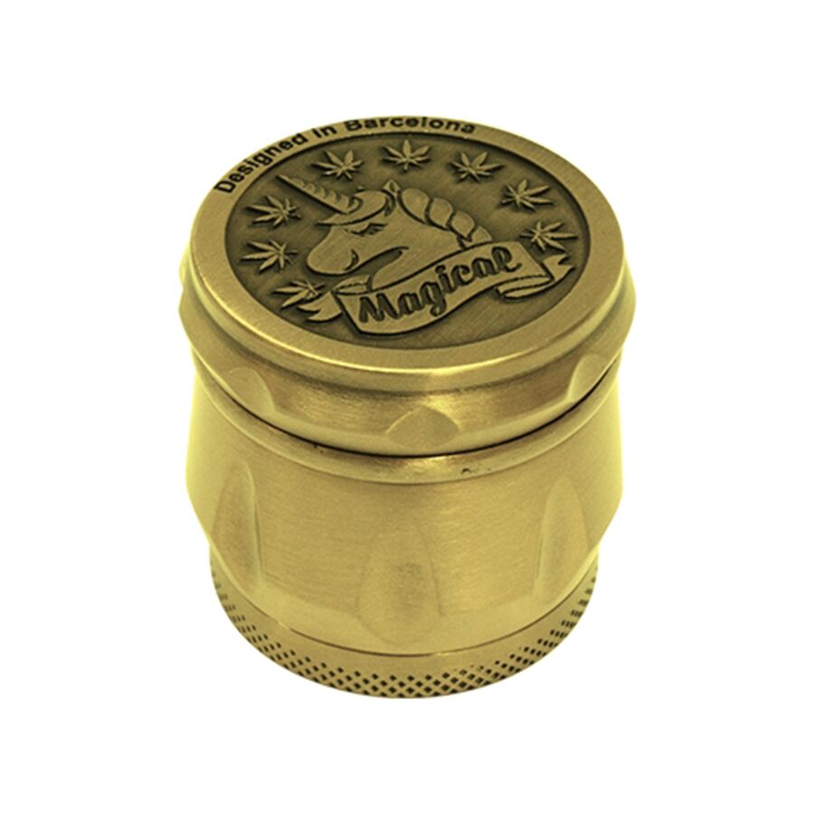 En gylden, præget kværn pryder overfladen med sit glatte, metalagtige finish. Den har en cylindrisk form, og mønsteret på ydersiden skaber en taktil tekstur. Kværnen har en lille, afrundet knop øverst til drejning og er forsynet med en skarp, synlig åbning nederst. Den gyldne farve reflekterer lys og tilføjer et elegant udtryk.