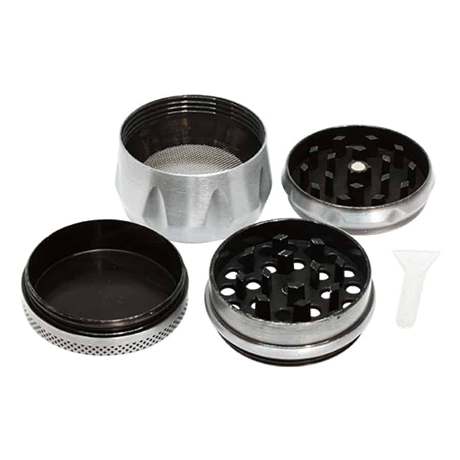 En sølvfarvet kværn i metal med en let struktureret overflade, der skaber en mat finish. Kværnen har en cylindrisk form med en rund top og bund. På toppen findes et lille håndtag, der er designet til at dreje. Der er præcise udskæringer og mønstre, der giver et dekorativt præg. Den samlede konstruktion udstråler soliditet og holdbarhed.