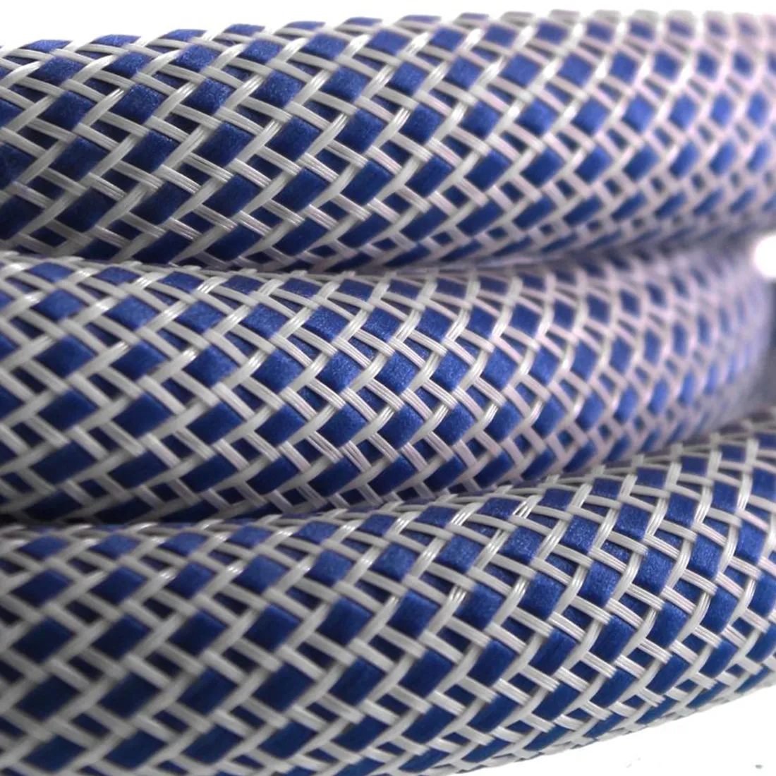 En slange i nylon er præsenteret i en klar blå farve, med en længde på 150 cm. Slangen har en glat overflade, der reflekterer lys, og dens struktur er ensartet uden synlige mønstre. Enderne er afsluttet med robuste fittings, der sikrer en tæt forbindelse. Materialet fremstår fleksibelt og let, ideelt til transport og opbevaring.