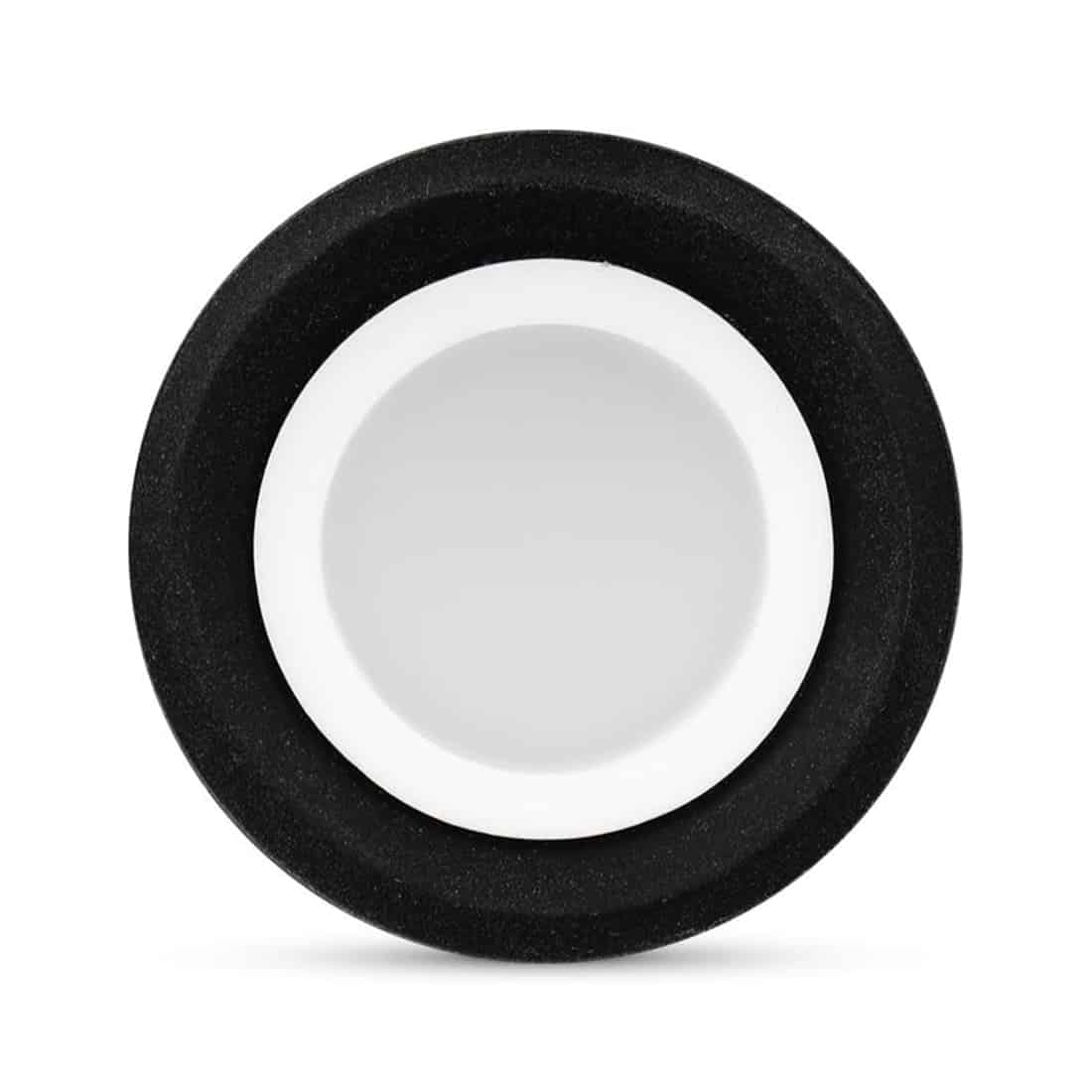 En lille, skinnende forsegling med en klar, glasklar beholder, der har en rund form. Beholderens kant er let buet og har en glat overflade. Den indre del er opdelt i to sektioner, hvor den øverste del har en mindre diameter. Farven er næsten gennemsigtig, med svage nuancer af hvid og blå, der giver et elegant præg.