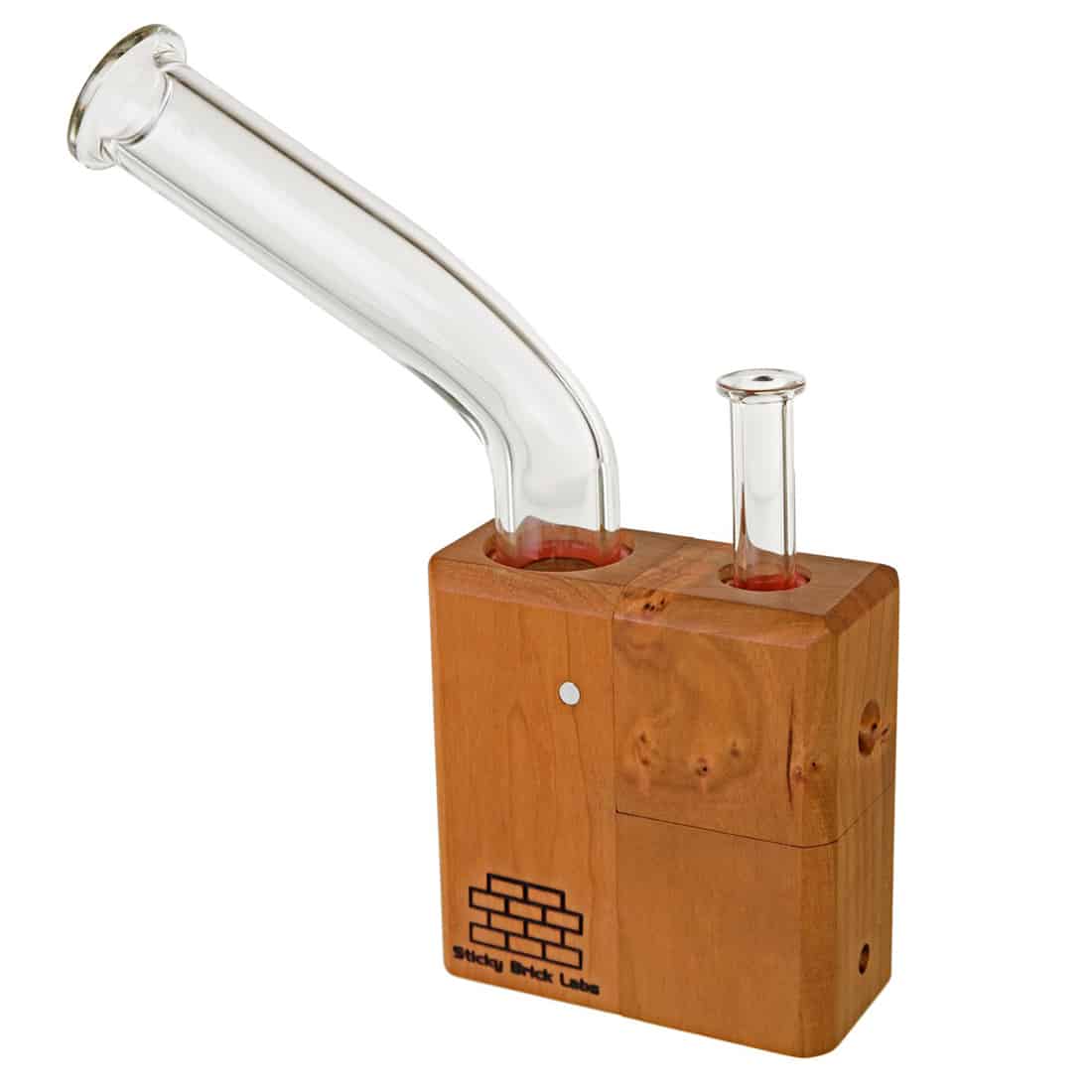 En lille, rektangulær enhed med en glat, sort overflade og rundede hjørner pryder midten. Den har en transparent skuffe, der viser en rød-brun substans inden i. Øverst er der en cirkulær knap med en sølvfarvet kant. En udtagelig, transparent slange er tilsluttet en side, og en halvtransparent, oval skive er synlig på den anden side.