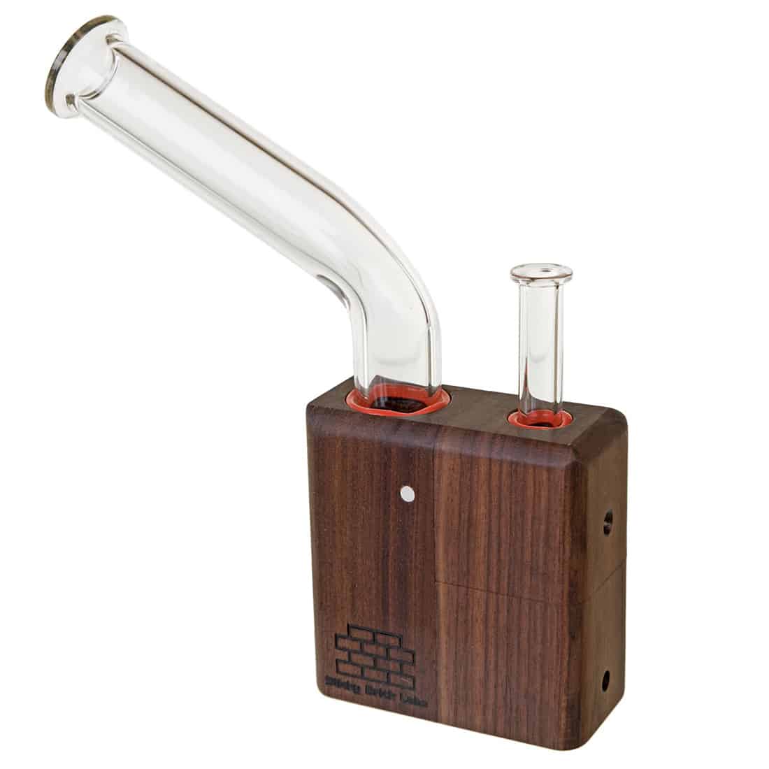 Sticky Brick Lab's Brick er konstrueret af mørkt valnøddetræ, hvilket giver en rig, dyb farve og en glat, naturlig overflade. Den har en minimalistisk form med bløde kanter og en indbygget glasrør, der strækker sig ud til en mundstykke. Der er synlige samlinger og detaljer, der fremhæver håndværket, samt en diskret logo-indsats.