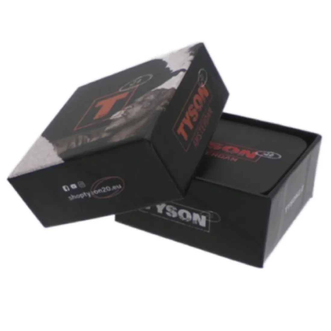 En cylindrisk grinder med en diameter på 54 mm, fremstillet af metal med en glat, poleret overflade. Den har en sølvfarvet finish, der reflekterer lys. Låget har et indgraveret mønster, mens de indvendige tænder er skarpe og designet til effektivt at male. Der er en lille åbning til opbevaring, der er centralt placeret.